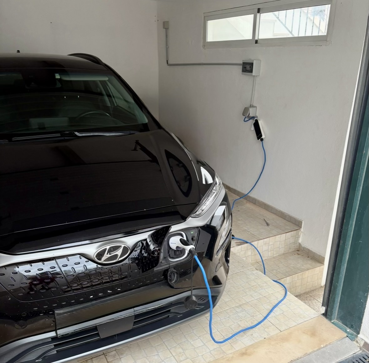 The car in the garage, charging at 12 A from the house's solar surplus.